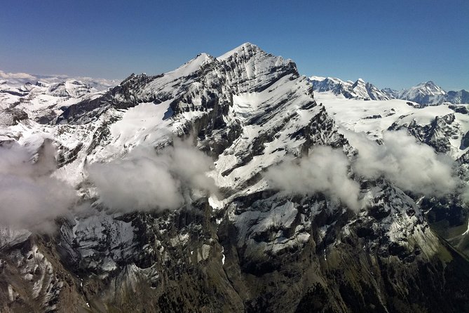 Private Swiss Alps helicopter tour over snow covered mountain peaks and glaciers - The colors of Lake Thun and Lake Brienz